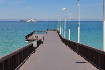 Obraz premium A pier with a boat in the distance and a boat in the distance.