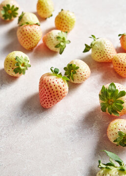 Arranged pineberries (white strawberries) on textured background