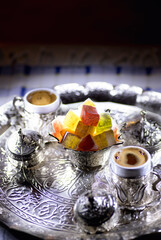Close up shot of Turkish delights and Turkish coffees in an ottoman style tray and cups