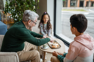 grandfather with his two grandchildren eating in a restaurant