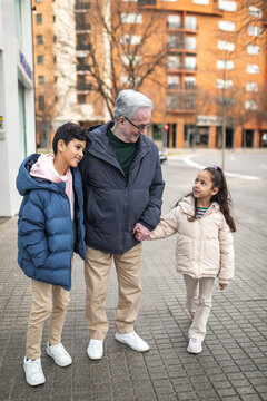 grandfather with grandchildren walking around the city