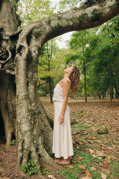 Portrait of a woman with an old tree in the park