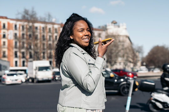 Stylish woman using smartphone on street