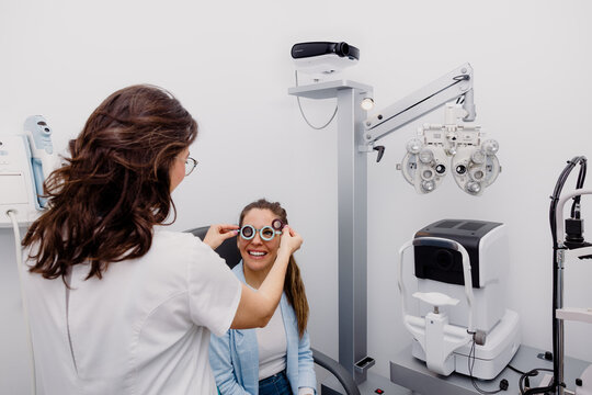 Oculist putting trial frame on patient