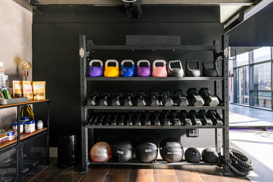 Gym rack with a set of dumbbells, kettlebells and exercise balls