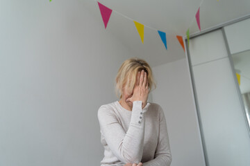 Depressed mature woman at home. Sad face with hands. Mental health problems, gaslighting or bulling...