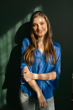 smiling woman standing  in the sunlight 