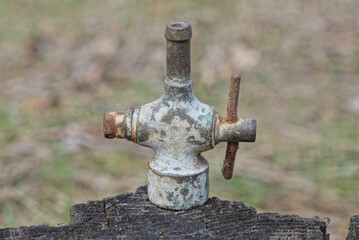 part one metal copper valve from an old faucet pipe on a gray table in the street