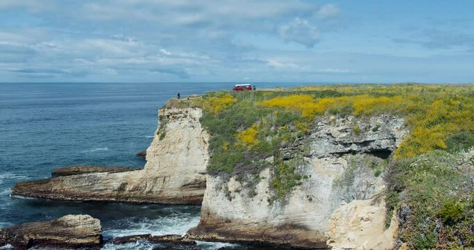 Vintage Van Drives Up To Ocean Cliff Edge With Waves Crashing Below