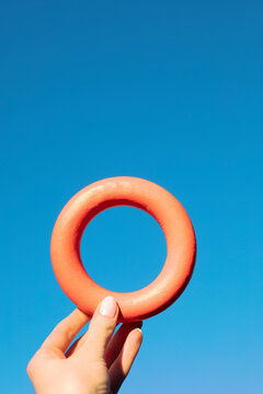 Hand holding a red torus and blue sky background