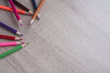 Blank wooden table with colorful pencils. Copy space for advertisement, text, or messages