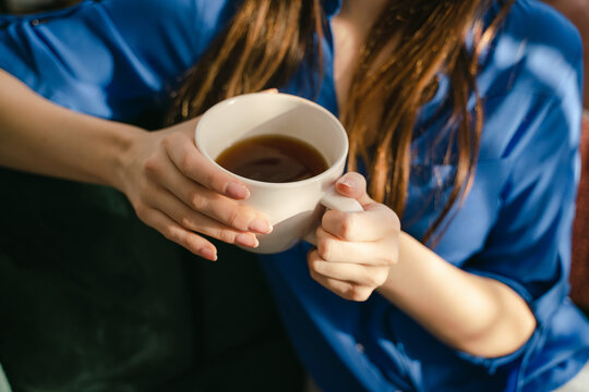 anonymous hands of  woman drinking tea