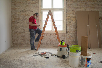 A construction worker is using a phone app