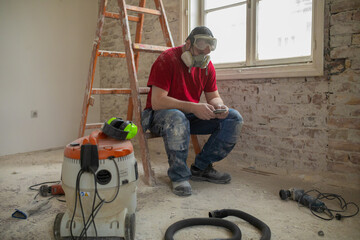 A construction worker is using a phone app