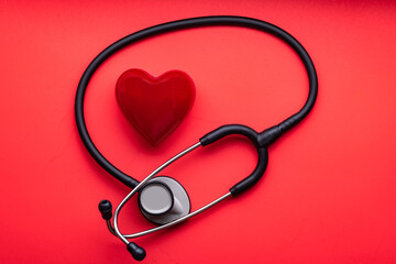 stethoscope and red heart on a red background. View from above.