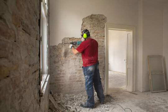 Construction worker working on the old interior wall