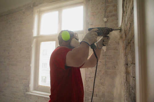 Construction worker working on the old interior wall