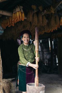 Cheerful Vietnamese local woman working with hemp in her workshop