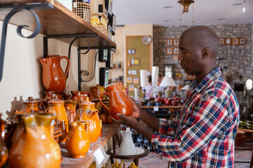 African-american shopper chooses handcrafted ceramic products. High quality photo