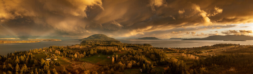 Beautiful Island Sunset With Dramatic Storm Clouds Across the Salish Sea Area of the Pacific Northwest. Aerial panoramic view of Lummi Island, Washington just after a spring rain shower.
