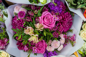 Pink, red and orange chrysanthemums, lisianthus and gerbera with green eucalyptus in a bouquet in red tones