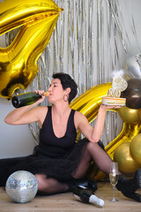 Caucasian woman drinking champagne from bottle celebrating her 40 birthday in a party.