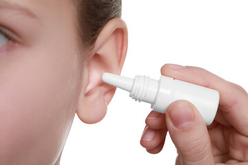 Mother dripping medication into daughter's ear on white background, closeup