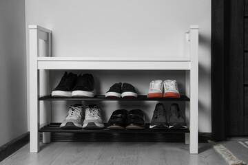 Shoe storage bench near white wall in hallway. Interior design