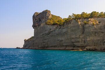 Naklejka premium View of the rocky shore from the sea. Mediterranean Sea in Turkey. Popular tourist places. Background