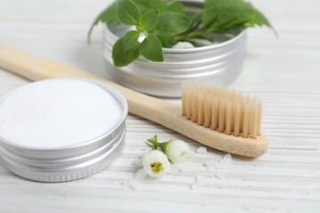 Fototapeta na wymiar Toothbrush, dental products and herbs on white wooden table, closeup