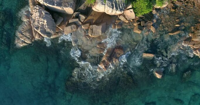 Aerial view waves break on  island beach at sunset. Sea waves on the beautiful island aerial view drone 4k Anse Lazio Beach, Praslin Island, Seychelles. people on the beach