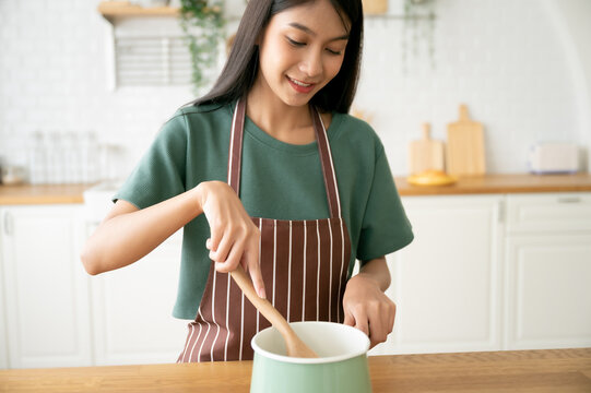 Young beauty asian woman cooking in kitchen room at home