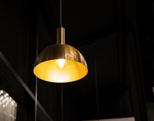 gold incandescent lamp On the black ceiling in the cafe