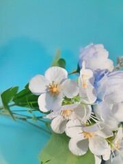 Fototapeta na wymiar Close up white simple plastic flower decoration on blue background