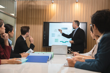 Professional team of focused business executives analyzing company annual financial paper report to balance together at office. Business market with modern office and tax document concept