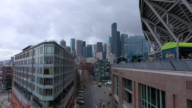 Aerial drone shot flying toward downtown Seattle, Washington skyline on a cloudy day.