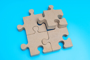 Wooden Jigsaw Puzzle parts on blue background. four puzzles form a rectangle on blue background. top view