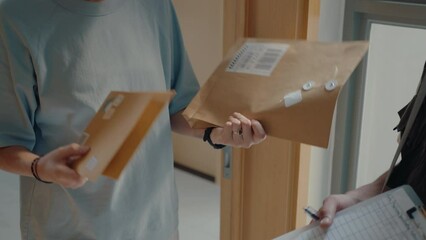Male courier delivering express mail to female client at home, giving her document for signing, then leaving. Medium close-up, tilt-up shot
