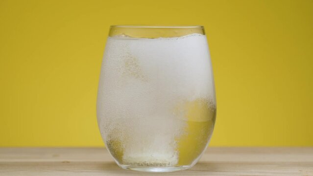 Magnesium fizzy tablet drops in clear water and dissolves in real time