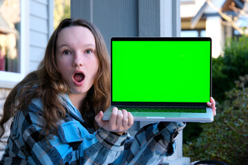 joy surprise happiness girl holding laptop with green screen chroma key sitting on street teenager pointing fingers at screen ad internet online learning entertainment sports interesting purchase