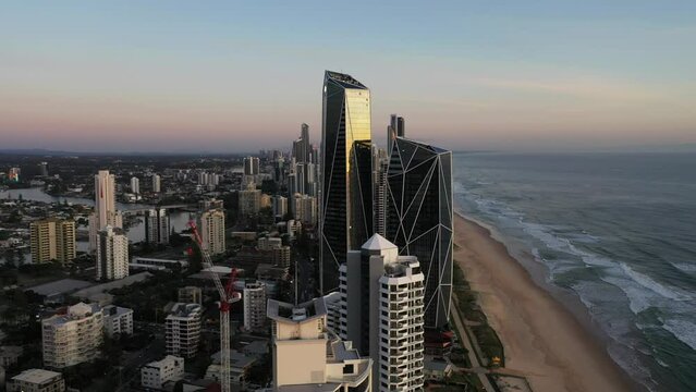 Aerial sunrise circle around from beach to ocean, Surfers Paradise cityscape. Gold Coast, Austraila