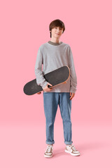 Naklejka premium Teenage boy with skateboard on pink background