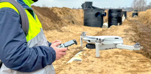 a surveyor with a quadcopter on a construction site
