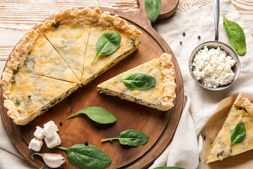 Board with pieces of delicious quiche and cottage cheese on white wooden background