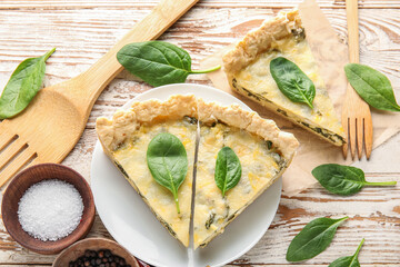 Plate with pieces of delicious quiche and salt on white wooden background