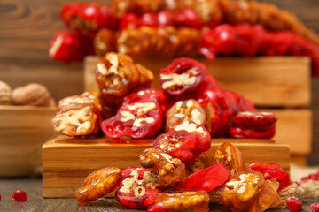 Board with delicious churchkhela on wooden table