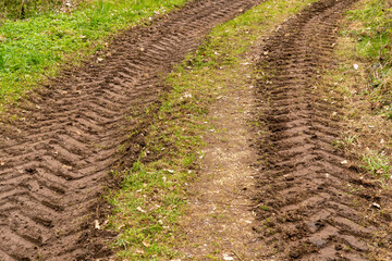 Tyre tracks of a tractor in the mud in a meadow in the mud
