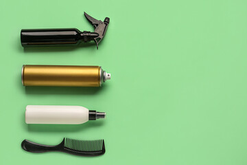 Bottles of hair sprays and comb on color background