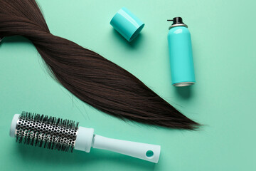 Naklejka premium Bottle of hair spray, brush and strand on color background