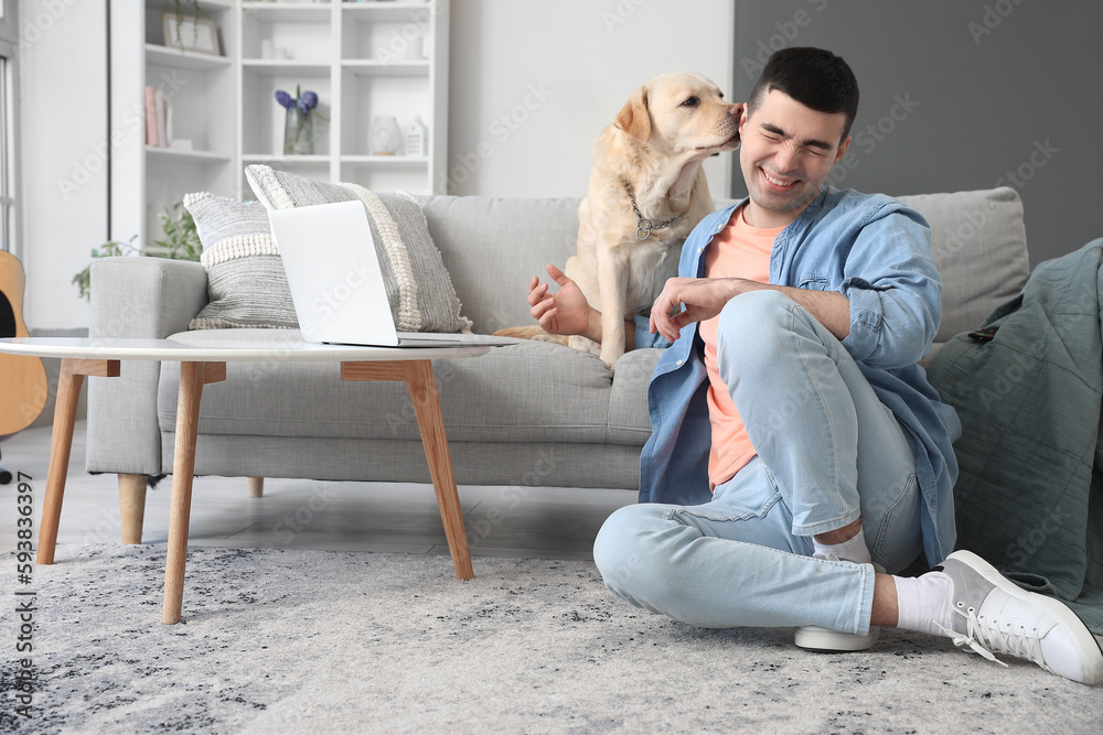 Canvas Prints Young man with cute Labrador dog at home